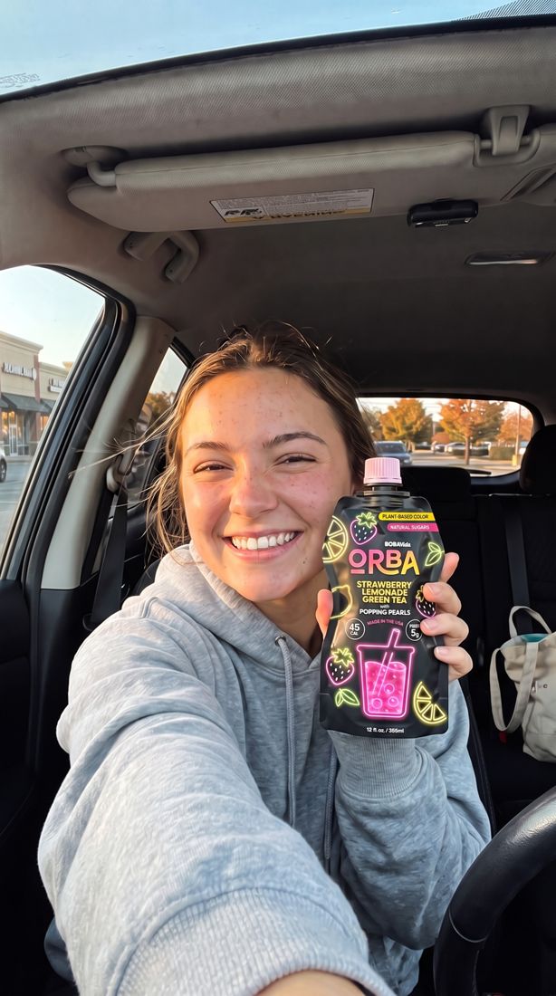 Creator selfie in a car holding ORBA Strawberry Lemonade